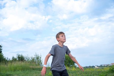 Bir çocuk futbol topuna tekme atıp kafa atmaya hazırlanıyor.