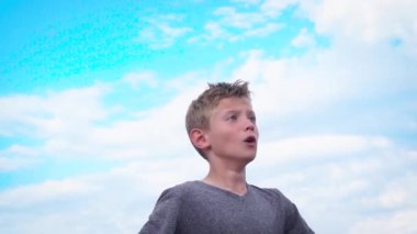 Bir çocuk futbol topuna tekme atıp kafa atmaya hazırlanıyor.