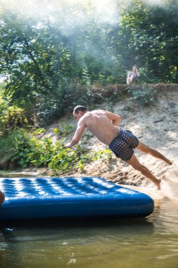 Bir çocuk sıcak bir günde yazın nehirde banyo yapar.