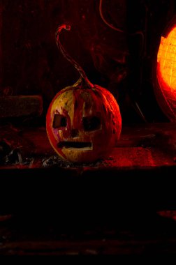 Kırmızı ışıkta balkabaklarıyla ve eski gaz lambalarıyla korkunç bir cadılar bayramı ve karanlık ve korkunç bir yerde kutlama hazırlığı.