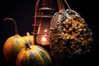 Kırmızı ışıkta balkabaklarıyla ve eski gaz lambalarıyla korkunç bir cadılar bayramı ve karanlık ve korkunç bir yerde kutlama hazırlığı.