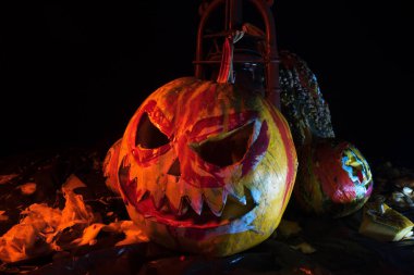 Kırmızı ışıkta balkabaklarıyla ve eski gaz lambalarıyla korkunç bir cadılar bayramı ve karanlık ve korkunç bir yerde kutlama hazırlığı.