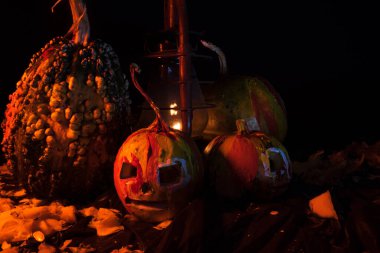 Kırmızı ışıkta balkabaklarıyla ve eski gaz lambalarıyla korkunç bir cadılar bayramı ve karanlık ve korkunç bir yerde kutlama hazırlığı.