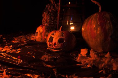 Kırmızı ışıkta balkabaklarıyla ve eski gaz lambalarıyla korkunç bir cadılar bayramı ve karanlık ve korkunç bir yerde kutlama hazırlığı.