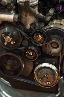 Bir tamirci tamir ve akort için kırmızı asansörde eski kirli bir araba motorunu söker.