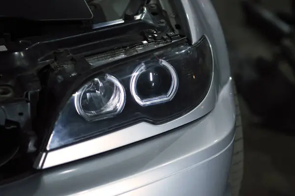 Bir tamirci tamir ve akort için kırmızı asansörde eski kirli bir araba motorunu söker.