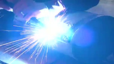 Eski bir arabanın egzoz sisteminin tamiri, öğütücüyle çalışmak, kaynak yapmak, gürültü emici yün yerleştirmek.