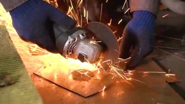 Eski bir arabanın egzoz sisteminin tamiri, öğütücüyle çalışmak, kaynak yapmak, gürültü emici yün yerleştirmek.