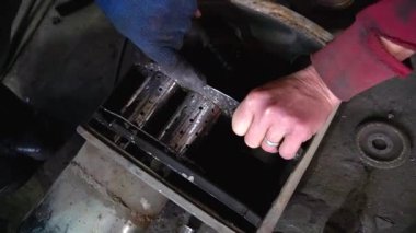 Eski bir arabanın egzoz sisteminin tamiri, öğütücüyle çalışmak, kaynak yapmak, gürültü emici yün yerleştirmek.