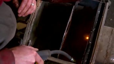Eski bir arabanın egzoz sisteminin tamiri, öğütücüyle çalışmak, kaynak yapmak, gürültü emici yün yerleştirmek.