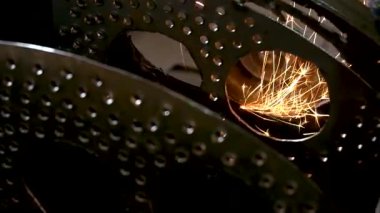 Eski bir arabanın egzoz sisteminin tamiri, öğütücüyle çalışmak, kaynak yapmak, gürültü emici yün yerleştirmek.