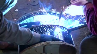 Eski bir arabanın egzoz sisteminin tamiri, öğütücüyle çalışmak, kaynak yapmak, gürültü emici yün yerleştirmek.