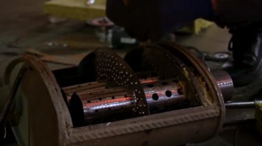 Eski bir arabanın egzoz sisteminin tamiri, öğütücüyle çalışmak, kaynak yapmak, gürültü emici yün yerleştirmek.