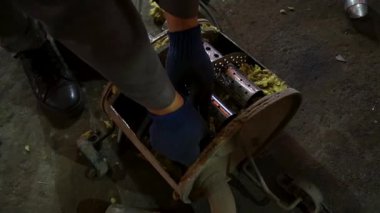 Eski bir arabanın egzoz sisteminin tamiri, öğütücüyle çalışmak, kaynak yapmak, gürültü emici yün yerleştirmek.