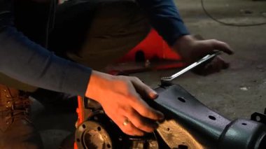 Özel egzoz sistemi ve egzoz manifoldu araba genç tamirci tamir ve eski gri bir araba monte bir trafik kazası sonra arka süspansiyon yeni sessiz bloklar baskı arka süspansiyon onarım ve yeni fren diskleri yükleme