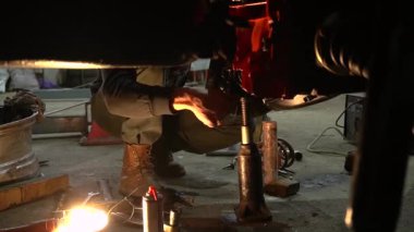 Özel egzoz sistemi ve egzoz manifoldu araba genç tamirci tamir ve eski gri bir araba monte bir trafik kazası sonra arka süspansiyon yeni sessiz bloklar baskı arka süspansiyon onarım ve yeni fren diskleri yükleme