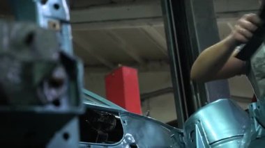 Özel egzoz sistemi ve egzoz manifoldu araba genç tamirci tamir ve eski gri bir araba monte bir trafik kazası sonra arka süspansiyon yeni sessiz bloklar baskı arka süspansiyon onarım ve yeni fren diskleri yükleme