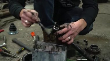 Özel egzoz sistemi ve egzoz manifoldu araba genç tamirci tamir ve eski gri bir araba monte bir trafik kazası sonra arka süspansiyon yeni sessiz bloklar baskı arka süspansiyon onarım ve yeni fren diskleri yükleme