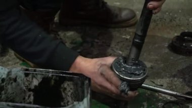 Özel egzoz sistemi ve egzoz manifoldu araba genç tamirci tamir ve eski gri bir araba monte bir trafik kazası sonra arka süspansiyon yeni sessiz bloklar baskı arka süspansiyon onarım ve yeni fren diskleri yükleme