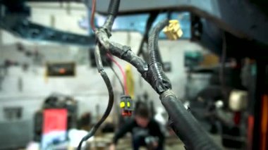 Özel egzoz sistemi ve egzoz manifoldu araba genç tamirci tamir ve eski gri bir araba monte bir trafik kazası sonra arka süspansiyon yeni sessiz bloklar baskı arka süspansiyon onarım ve yeni fren diskleri yükleme