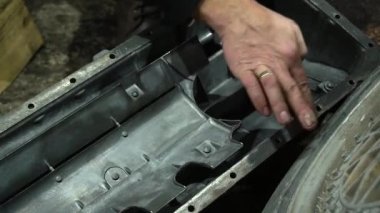 Özel egzoz sistemi ve egzoz manifoldu araba genç tamirci tamir ve eski gri bir araba monte bir trafik kazası sonra arka süspansiyon yeni sessiz bloklar baskı arka süspansiyon onarım ve yeni fren diskleri yükleme