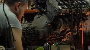 Özel egzoz sistemi ve egzoz manifoldu araba genç tamirci tamir ve eski gri bir araba monte bir trafik kazası sonra arka süspansiyon yeni sessiz bloklar baskı arka süspansiyon onarım ve yeni fren diskleri yükleme