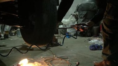 Özel egzoz sistemi ve egzoz manifoldu araba genç tamirci tamir ve eski gri bir araba monte bir trafik kazası sonra arka süspansiyon yeni sessiz bloklar baskı arka süspansiyon onarım ve yeni fren diskleri yükleme