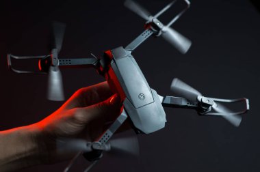 Karanlık bir odada bir insanın elindeki kırmızı ışıkla aydınlatılan bir kuadkopter uçma ve fırlatma simülasyonu