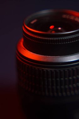 Kırmızı ışıkta, özel filtresi olan bir stüdyoda tripoda siyah SLR kamera kullanıldı.