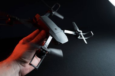 Karanlık bir odada bir insanın elindeki kırmızı ışıkla aydınlatılan bir kuadkopter uçma ve fırlatma simülasyonu