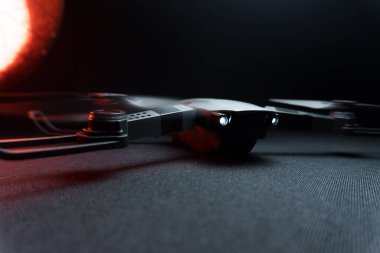 Karanlık bir odada bir insanın elindeki kırmızı ışıkla aydınlatılan bir kuadkopter uçma ve fırlatma simülasyonu