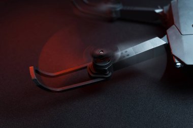 Karanlık bir odada bir insanın elindeki kırmızı ışıkla aydınlatılan bir kuadkopter uçma ve fırlatma simülasyonu