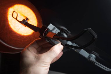 Karanlık bir odada bir insanın elindeki kırmızı ışıkla aydınlatılan bir kuadkopter uçma ve fırlatma simülasyonu