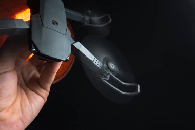 Karanlık bir odada bir insanın elindeki kırmızı ışıkla aydınlatılan bir kuadkopter uçma ve fırlatma simülasyonu