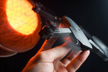 Karanlık bir odada bir insanın elindeki kırmızı ışıkla aydınlatılan bir kuadkopter uçma ve fırlatma simülasyonu