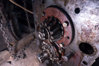 Eski bir garajda eski bir mavi traktörün tamiri, bir vites kutusunun sökülmesi ve montajı,