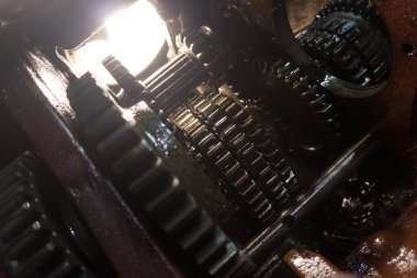 Eski bir garajda eski bir mavi traktörün tamiri, bir vites kutusunun sökülmesi ve montajı,