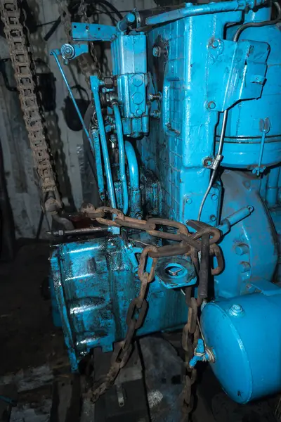 Eski bir garajda eski bir mavi traktörün tamiri, bir vites kutusunun sökülmesi ve montajı,