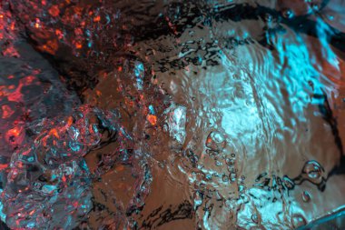 Su dokusu gürleyen kaos içinde hava kabarcıkları yaratıyor mavi ve kırmızı ışıkta dışarı kaçıyorlar.