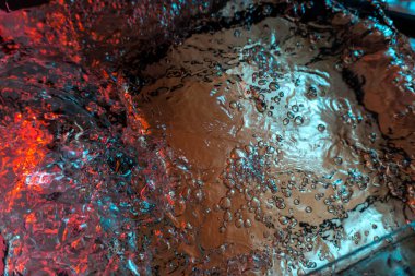 Su dokusu gürleyen kaos içinde hava kabarcıkları yaratıyor mavi ve kırmızı ışıkta dışarı kaçıyorlar.