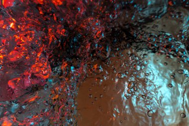 Su dokusu gürleyen kaos içinde hava kabarcıkları yaratıyor mavi ve kırmızı ışıkta dışarı kaçıyorlar.