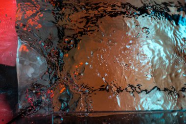 Su dokusu gürleyen kaos içinde hava kabarcıkları yaratıyor mavi ve kırmızı ışıkta dışarı kaçıyorlar.