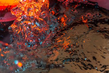 Bir volkanın lavında denizin taklidi, suyun dokusu kırmızı ışıkta çıkan hava kabarcıklarıyla kaos yaratıyor.