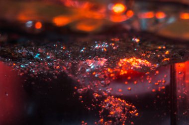 Bir volkanın lavında denizin taklidi, suyun dokusu kırmızı ışıkta çıkan hava kabarcıklarıyla kaos yaratıyor.