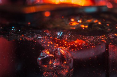 Bir volkanın lavında denizin taklidi, suyun dokusu kırmızı ışıkta çıkan hava kabarcıklarıyla kaos yaratıyor.