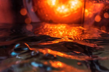 Bir volkanın lavında denizin taklidi, suyun dokusu kırmızı ışıkta çıkan hava kabarcıklarıyla kaos yaratıyor.