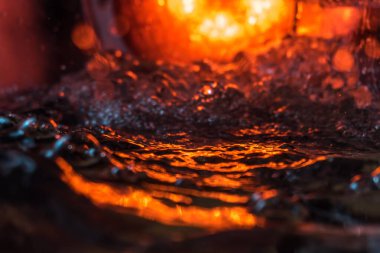 Bir volkanın lavında denizin taklidi, suyun dokusu kırmızı ışıkta çıkan hava kabarcıklarıyla kaos yaratıyor.