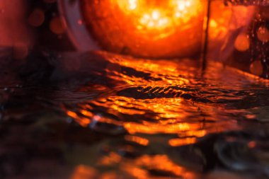 Bir volkanın lavında denizin taklidi, suyun dokusu kırmızı ışıkta çıkan hava kabarcıklarıyla kaos yaratıyor.