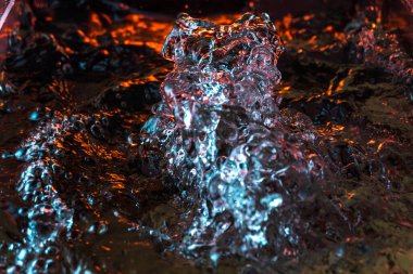 Bir volkanın lavında denizin taklidi, suyun dokusu kırmızı ışıkta çıkan hava kabarcıklarıyla kaos yaratıyor.