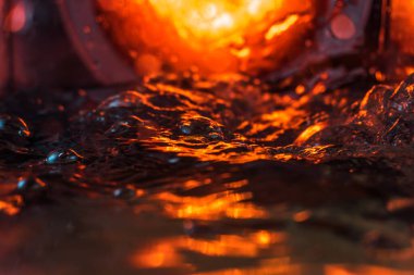 Bir volkanın lavında denizin taklidi, suyun dokusu kırmızı ışıkta çıkan hava kabarcıklarıyla kaos yaratıyor.